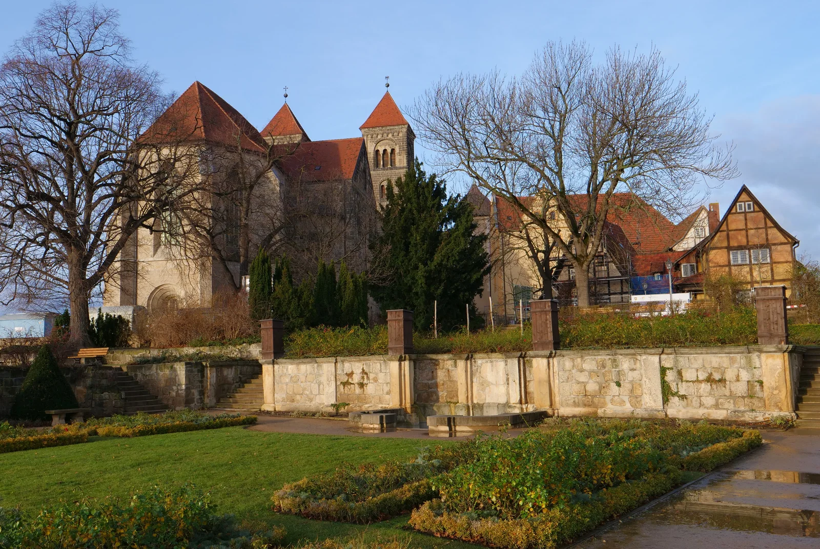 The twin towers of St Servatius and neighboring buildings above a stone terrace and leafless trees.