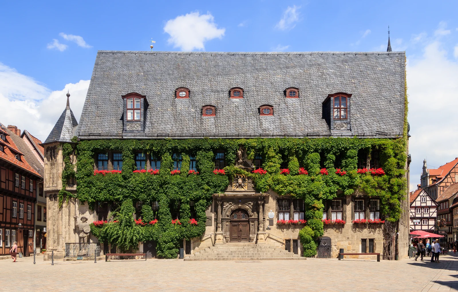 Quedlinburg town hall with ivy across its stone facade, red window frames and a steep slate roof.
